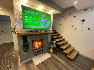a living room with a fireplace and a large screen at къща за гости Горски чар in Beli Osŭm