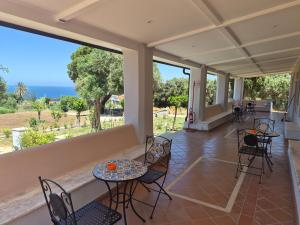 a patio with tables and chairs and a view of the ocean at Terra e Cielo Rooms in Parghelia