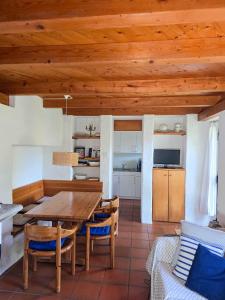 a kitchen and dining room with a wooden table and chairs at Rustico Marietta by HolAp SA in Brissago