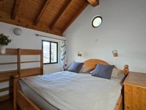 a bedroom with a bed with a wooden headboard and a window at Rustico Marietta by HolAp SA in Brissago