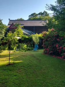 a yard with a blue chair in front of a house at "Chambres d'Hôtes" Bord de Rance Au Rez-de-Jardin de la "Villa Cyrano" in Pleurtuit