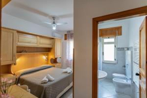 a bedroom with a bed and a toilet and a sink at Agriturismo EUCALIPTO in Perdifumo