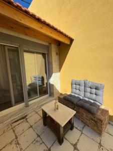 a couch on the side of a building with a table at Tiny Diamond in Plomari