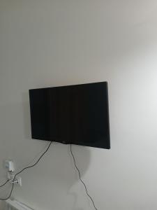 a flat screen tv hanging on a white wall at Tiny Diamond in Plomari