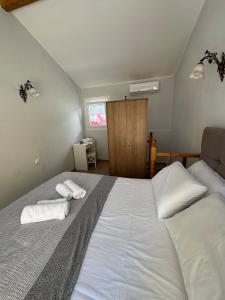 a bedroom with a large white bed with towels on it at Tiny Diamond in Plomari