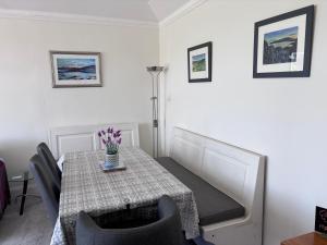 a dining room table with a vase of flowers on it at Fairview Millport in Millport