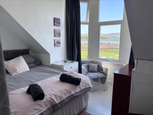 a bedroom with two beds and a window at Fairview Millport in Millport