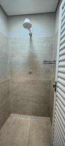 a bathroom with a shower with a light on the ceiling at Chácara Umbelina Hospedaria in Cachoeira Paulista +9 photos