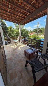 a porch with a hammock and a table and chairs at Pousada & Hostel América in Barreirinhas
