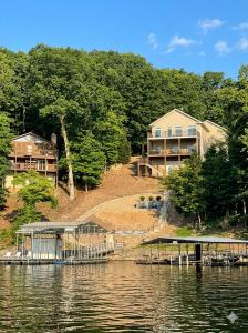 a house on the shore of a body of water at Lakefront Villa with Dock Swim Platform in Lake Ozark