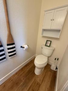a small bathroom with a toilet and a cabinet at Lakefront Villa with Dock Swim Platform in Lake Ozark +8 photos