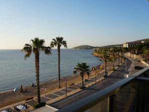 a view of a beach with palm trees and the ocean at Ciftlique Otel Cesme in Çeşme