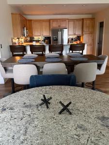 a dining room with a table and chairs and a kitchen at Lakefront Villa with Dock Swim Platform in Lake Ozark