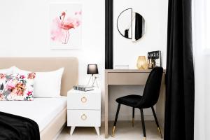a bedroom with a desk and a bed with a chair at OCCO by the Jacuzzi in Popeşti-Leordeni
