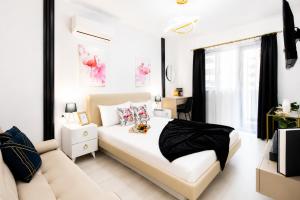 a bedroom with a large white bed and a couch at OCCO by the Jacuzzi in Popeşti-Leordeni