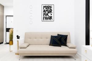 a white couch in a living room with a sign on the wall at OCCO by the Jacuzzi in Popeşti-Leordeni +33 photos