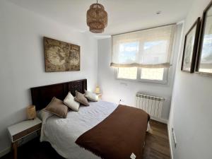 a bedroom with a bed and two windows at El Cubo in La Lastrilla