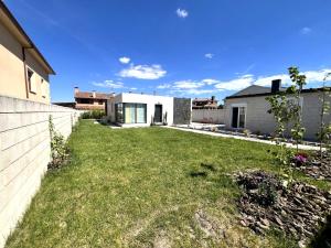 a backyard of a house with a green yard at El Cubo in La Lastrilla