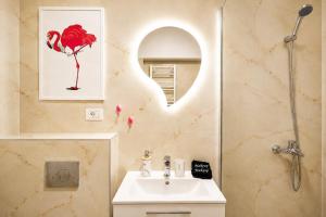 a bathroom with a sink and a mirror at OCCO by the Jacuzzi in Popeşti-Leordeni