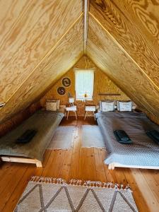 a room with two beds in a wooden house at Chatka u Radka in Szczodrowo +18 photos