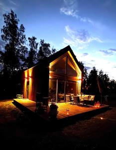 a small cabin with a wooden deck at night at Chatka u Radka in Szczodrowo