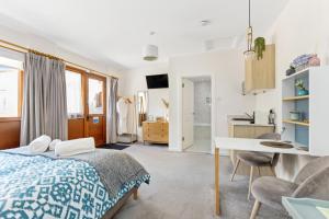 a bedroom with a bed and a desk and a kitchen at Glenarch House in Dalkeith