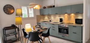 a kitchen with a table and some chairs and a stove at Le murmure des pins in Villemoustaussou