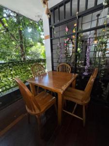 a wooden table and chairs with flowers on a balcony at Casa Raizal in Envigado +17 photos
