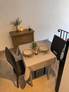 a dining room table with plates and candles on it at Le Refuge de la Tour entre mer et ciel in Porri