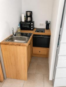 a small kitchen with a sink and a microwave at Le Refuge de la Tour entre mer et ciel in Porri +38 photos