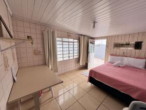 a bedroom with a bed and a table in it at Casa de Fundos com 2 QuartosWi-fi e Estacionamento in Lages