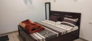 a bed with a wooden headboard and pillows on it at MR HOTEL & family restaurant Ringus in Rīngas