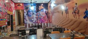 a restaurant with tables and a large mural on the wall at MR HOTEL & family restaurant Ringus in Rīngas