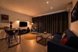a living room with a couch and a table and a desk at Vinyl & Wine Retreat by THE HOUSE Experience Collection in Škaljari +2 photos