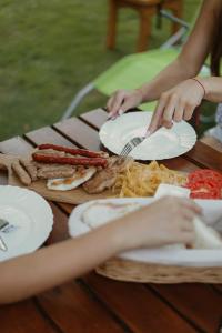 a group of people sitting at a table with plates of food at Zicka plaza in Kraljevo