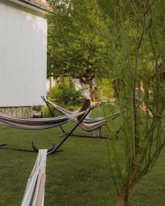 a woman sitting in a hammock in a yard at Zicka plaza in Kraljevo +32 photos