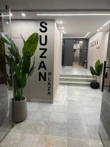a lobby with a plant and a sign that reads sz zero zero at Suzan Hotel Apartments in Amman