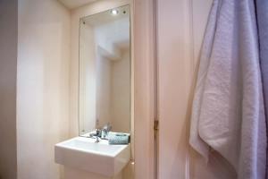 a bathroom with a sink and a mirror next to a shower at Guilford Loft in Corfu +8 photos