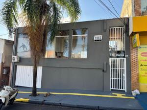 a house with a palm tree in front of it at ACONCHEGO 6 - Self Check-in in Presidente Prudente