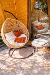 a wicker basket chair with pillows and a table at My Dream - Blidinje in Blidinje