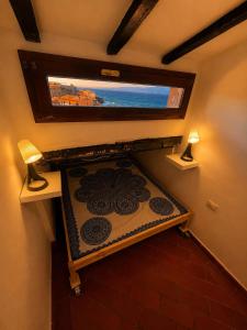 a room with a bed with a window and a television at Mansarda sopra i canali in Piombino