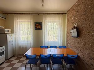 a kitchen with a table and blue chairs in a room at Мрія in Odesa +11 photos