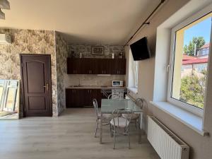 a kitchen with a table and chairs and a window at Мрія in Odesa