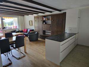 a kitchen and living room with a table and chairs at Bella Val (206 Se) in Lenzerheide