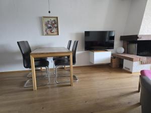 a dining room with a table and chairs and a television at Bella Val (206 Se) in Lenzerheide