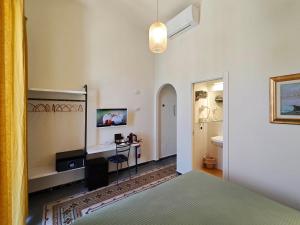 ein Schlafzimmer mit Bett, Schreibtisch und Fernseher in der Unterkunft Locanda Mari in Ponza