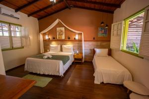 a bedroom with two beds and two windows at Chalés Terraviva in Pirenópolis +186 photos