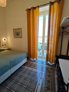 ein Schlafzimmer mit einem Bett und einem großen Fenster in der Unterkunft Locanda Mari in Ponza