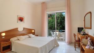 a bedroom with a bed and a window and a table at Raffy Family & Bike Hotel in Diano Marina
