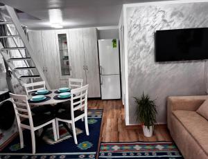 a living room with a table and chairs and a television at Sofia's home in Piatra Neamţ